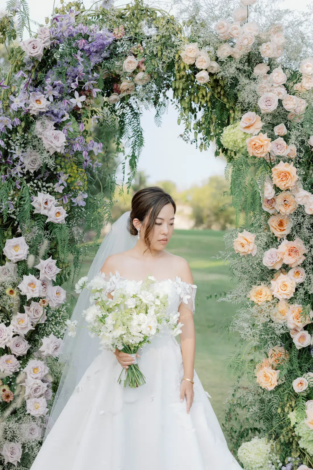 Bride Framed By Floral Arch Holding Bouquet