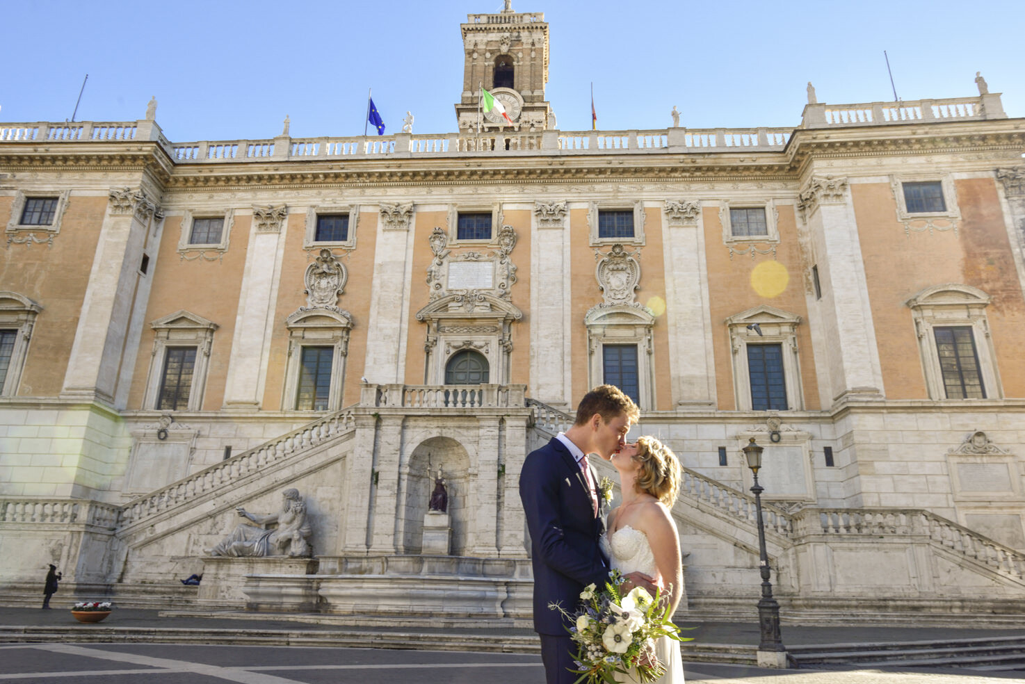 Bridal couple kissing in front of Campidoglio Palace