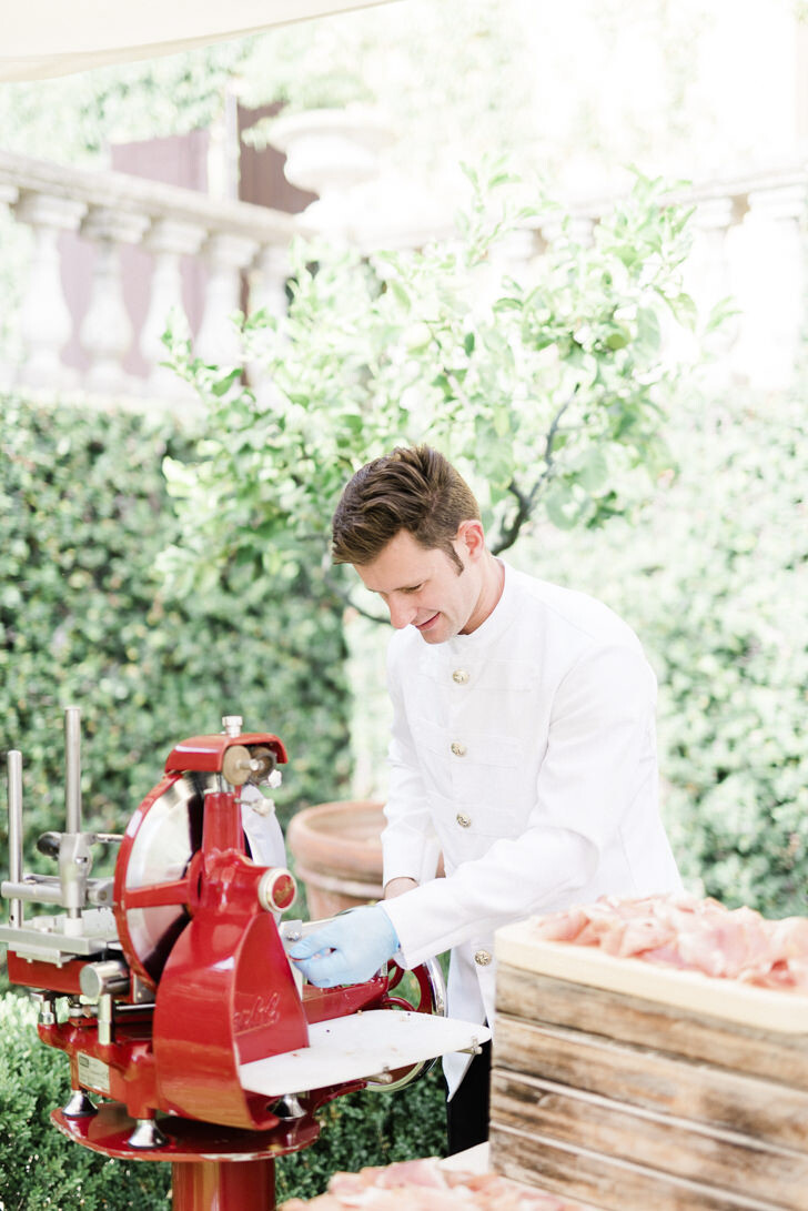 Italian waiter preparing prosciutto